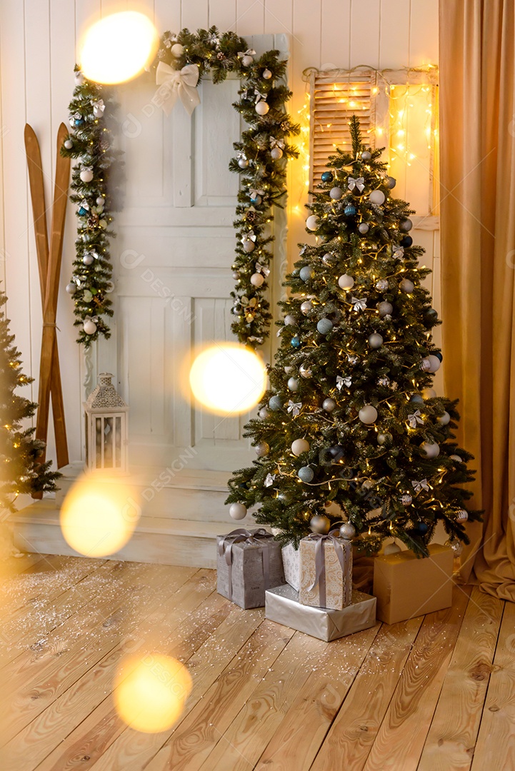 Lindo quarto decorado com árvore de Natal com presentes debaixo dela.