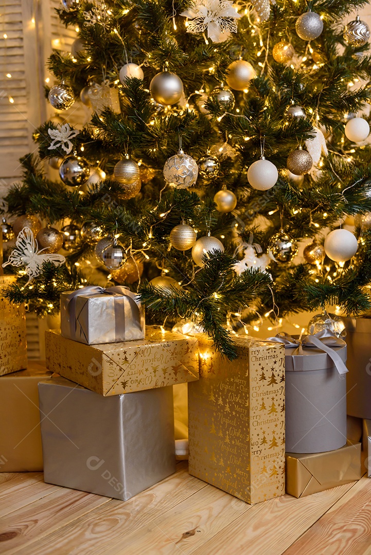 Lindo quarto decorado com árvore de Natal com presentes debaixo dela.