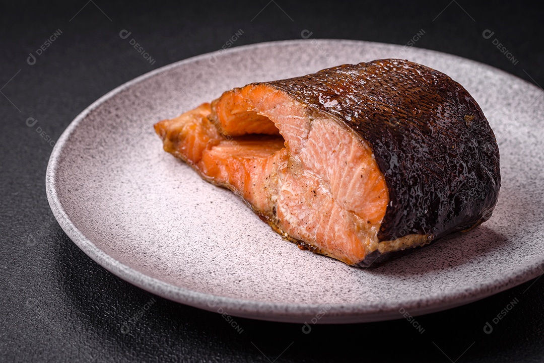 Bife de salmão delicioso cozido fresco com especiarias e ervas assadas em uma grelha. Comida saudável de frutos do mar