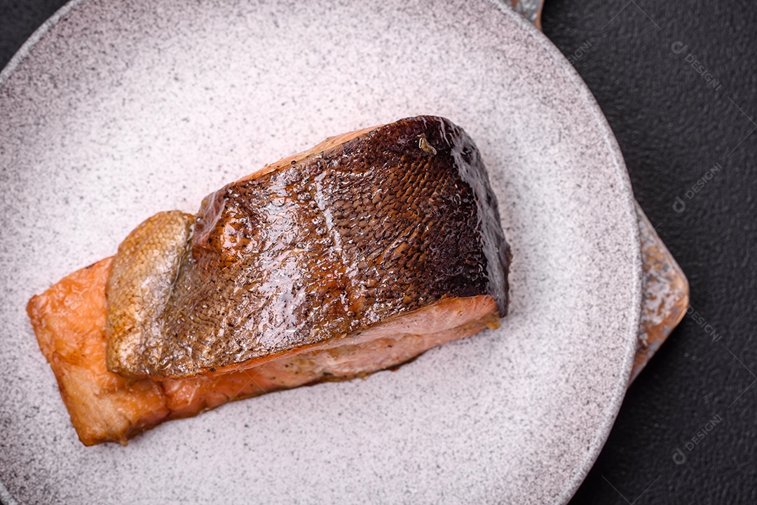 Bife de salmão delicioso cozido fresco com especiarias e ervas assadas em uma grelha. Comida saudável de frutos do mar