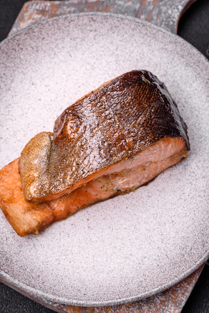 Bife de salmão delicioso cozido fresco com especiarias e ervas assadas em uma grelha. Comida saudável de frutos do mar