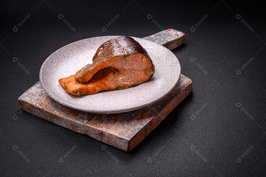 Bife de salmão delicioso cozido fresco com especiarias e ervas assadas em uma grelha. Comida saudável de frutos do mar