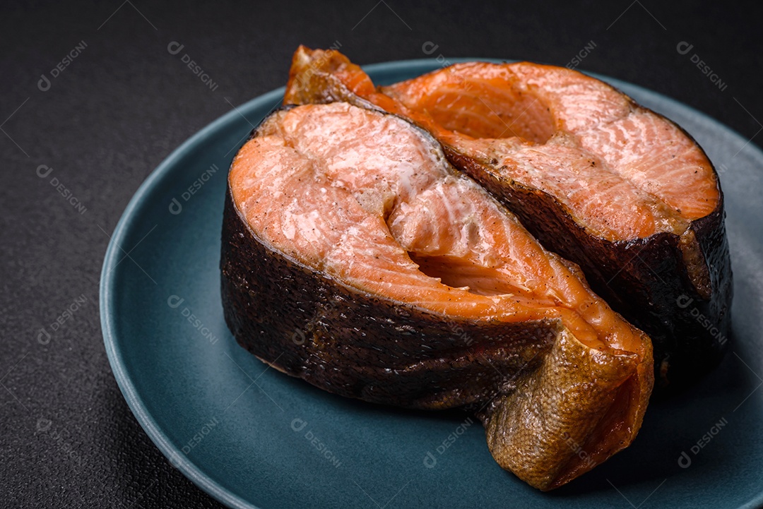 Bife de salmão delicioso cozido fresco com especiarias e ervas assadas em uma grelha. Comida saudável de frutos do mar