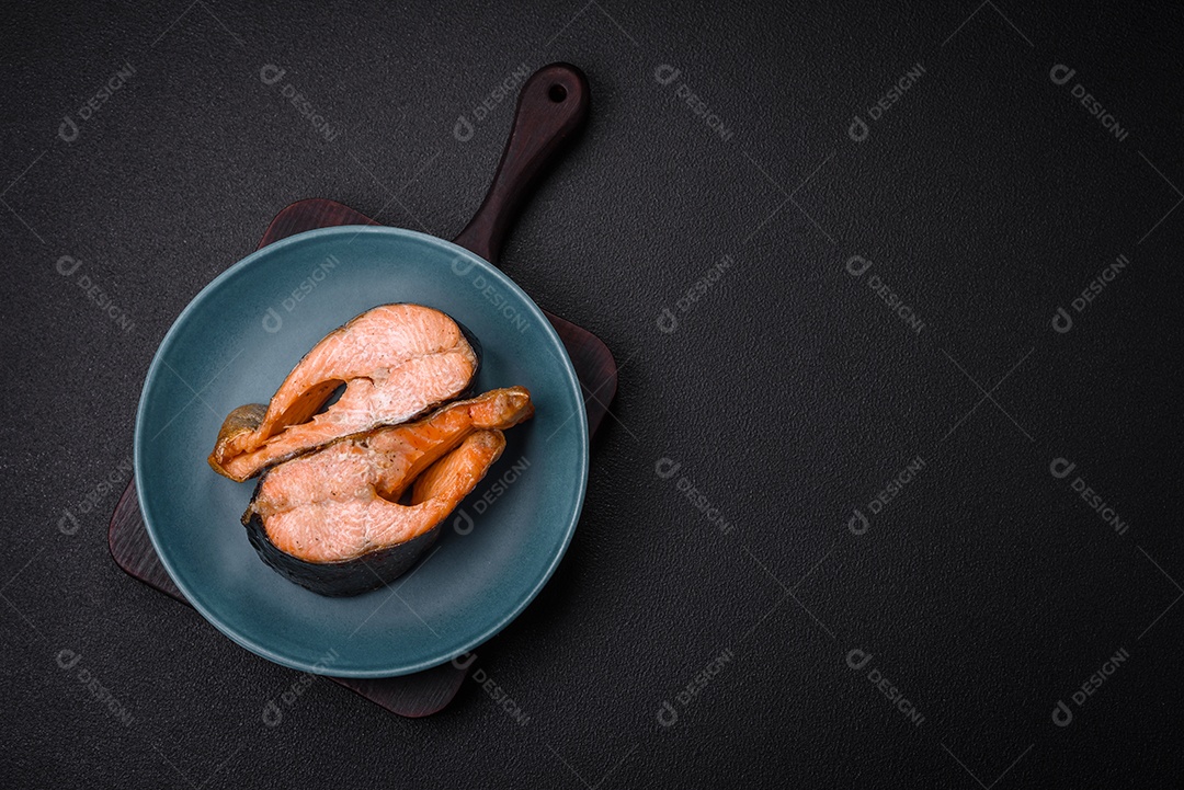 Bife de salmão delicioso cozido fresco com especiarias e ervas assadas em uma grelha. Comida saudável de frutos do mar