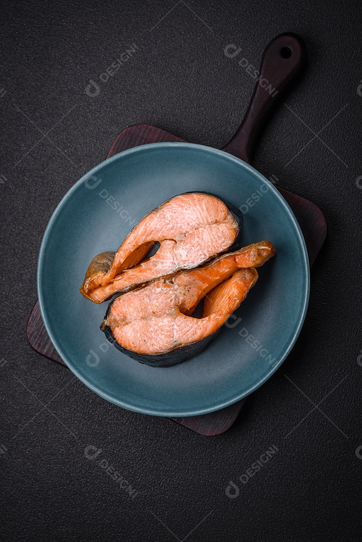 Bife de salmão delicioso cozido fresco com especiarias e ervas assadas em uma grelha. Comida saudável de frutos do mar
