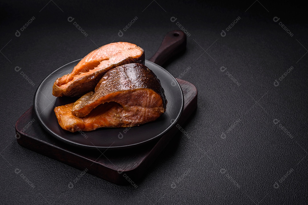 Bife de salmão delicioso cozido fresco com especiarias e ervas assadas em uma grelha. Comida saudável de frutos do mar