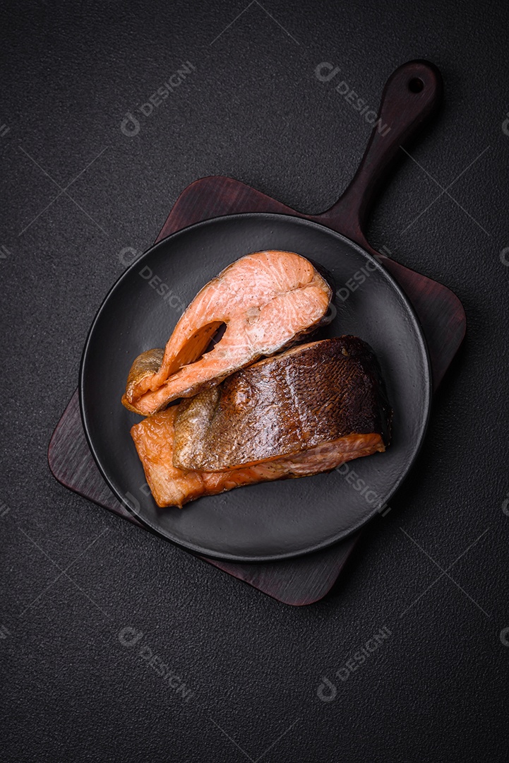 Bife de salmão delicioso cozido fresco com especiarias e ervas assadas em uma grelha. Comida saudável de frutos do mar
