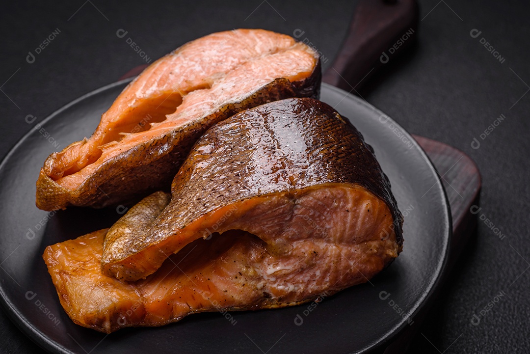 Bife de salmão delicioso cozido fresco com especiarias e ervas assadas em uma grelha. Comida saudável de frutos do mar