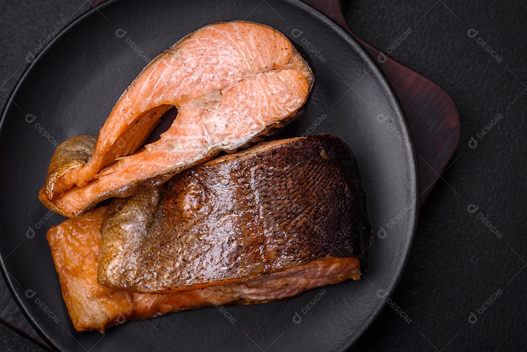 Bife de salmão delicioso cozido fresco com especiarias e ervas assadas em uma grelha. Comida saudável de frutos do mar