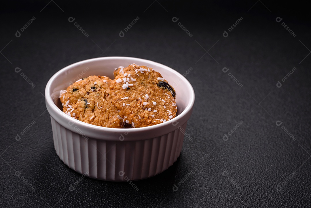 Deliciosos biscoitos redondos e doces polvilhados com flocos de coco sobre um fundo escuro de concreto
