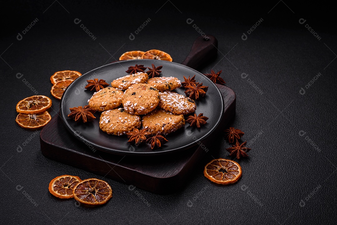 Deliciosos biscoitos redondos e doces polvilhados com flocos de coco sobre um fundo escuro de concreto