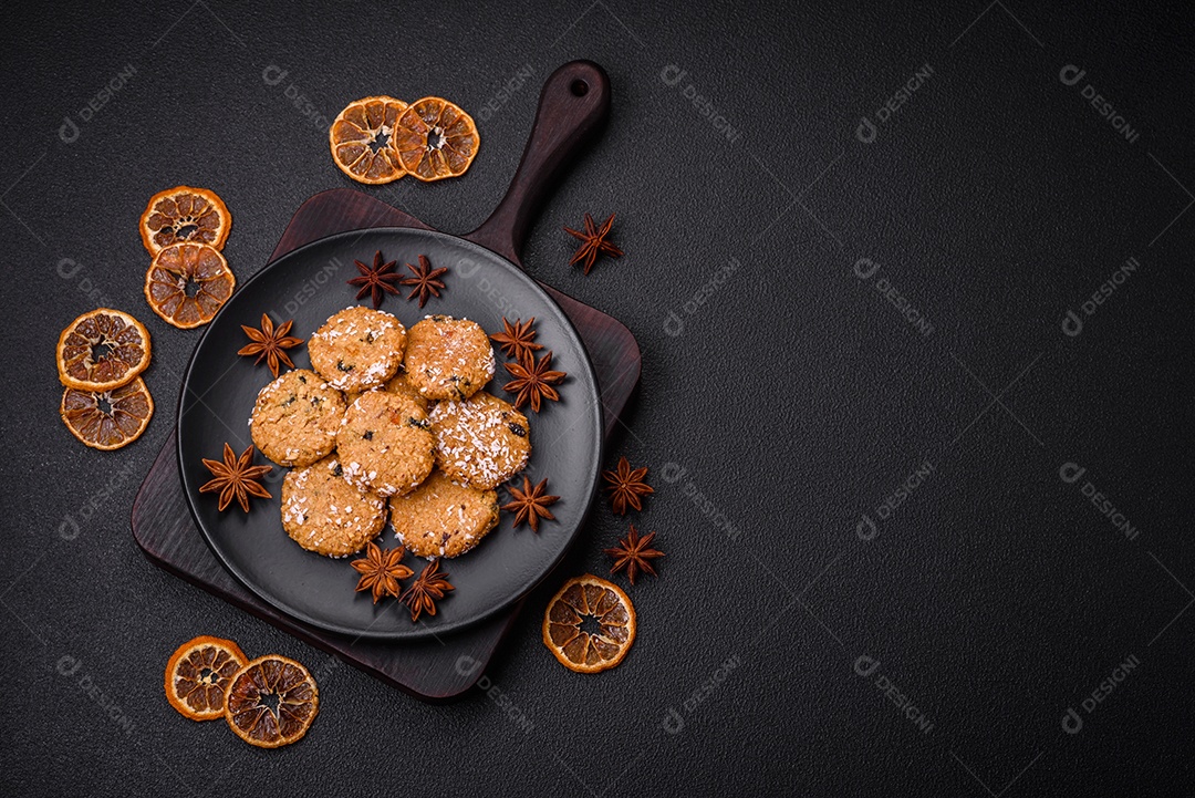 Deliciosos biscoitos redondos e doces polvilhados com flocos de coco sobre um fundo escuro de concreto
