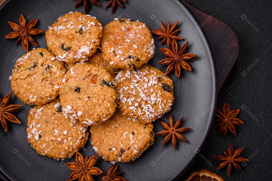 Deliciosos biscoitos redondos e doces polvilhados com flocos de coco sobre um fundo escuro de concreto