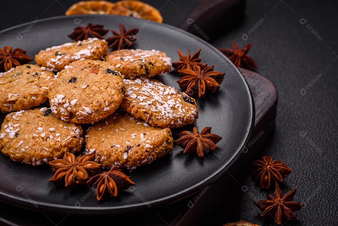 Deliciosos biscoitos redondos e doces polvilhados com flocos de coco sobre um fundo escuro de concreto