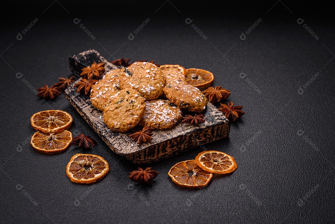 Deliciosos biscoitos redondos e doces polvilhados com flocos de coco sobre um fundo escuro de concreto