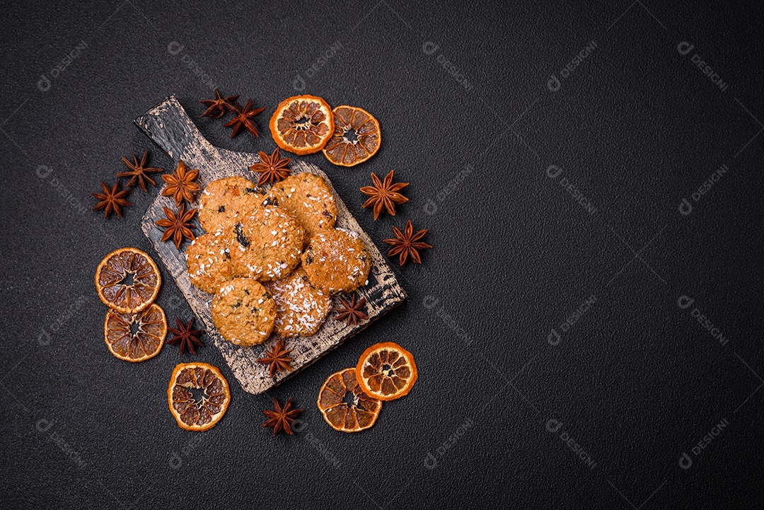 Deliciosos biscoitos redondos e doces polvilhados com flocos de coco sobre um fundo escuro de concreto