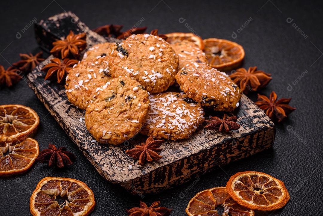 Deliciosos biscoitos redondos e doces polvilhados com flocos de coco sobre um fundo escuro de concreto