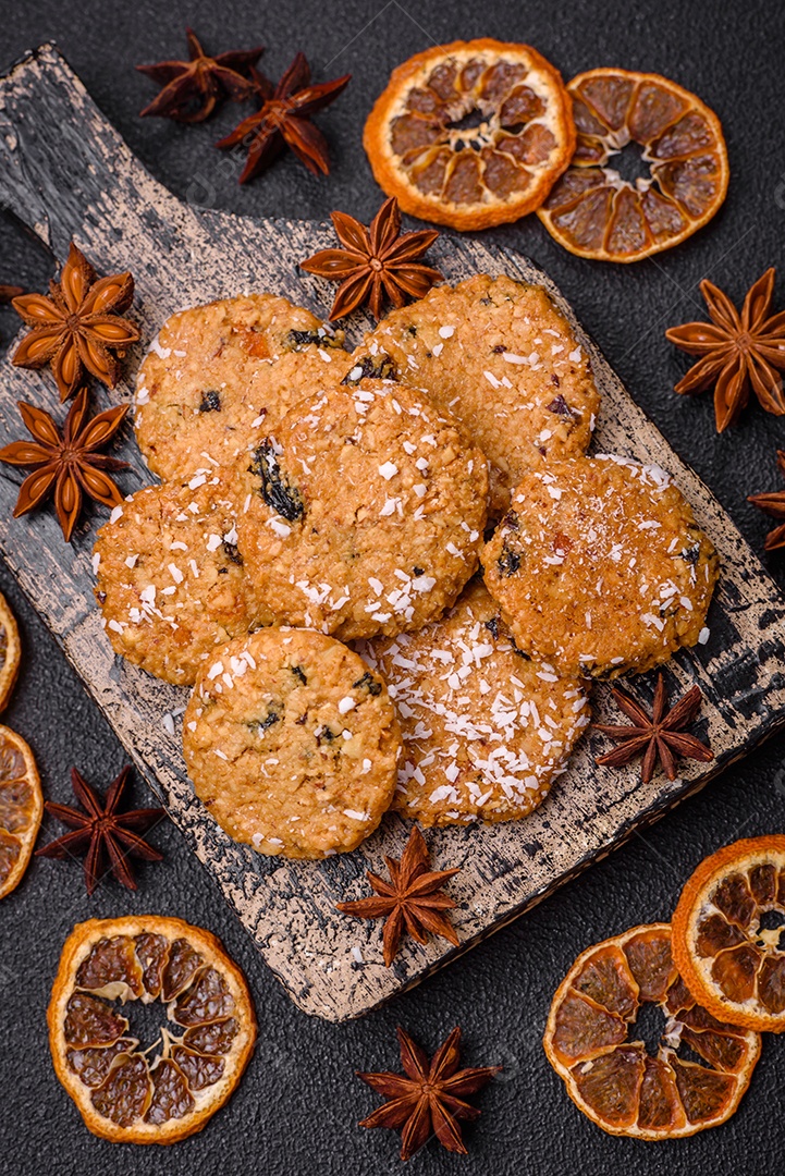 Deliciosos biscoitos redondos e doces polvilhados com flocos de coco sobre um fundo escuro de concreto