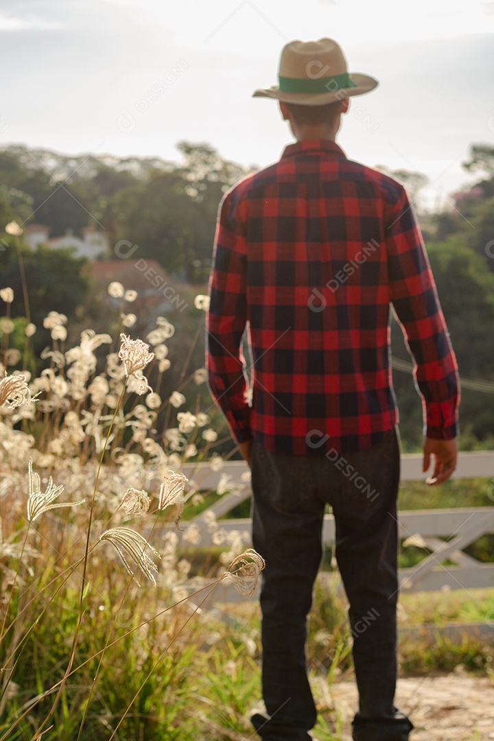 Jovem fazendeiro negro trabalhando em frente ao portão do fazendeiro