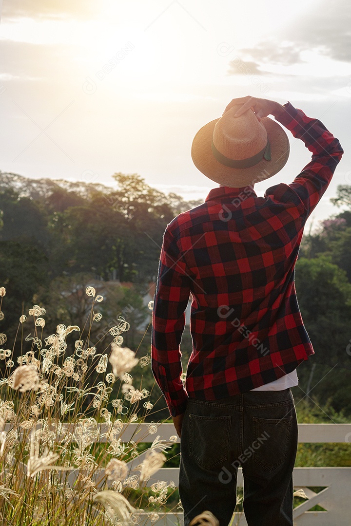 Jovem agricultor negro do sexo masculino trabalhando em frente ao portão dos agricultores.