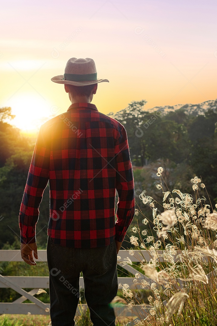 Jovem fazendeiro negro trabalhando em frente ao portão do fazendeiro