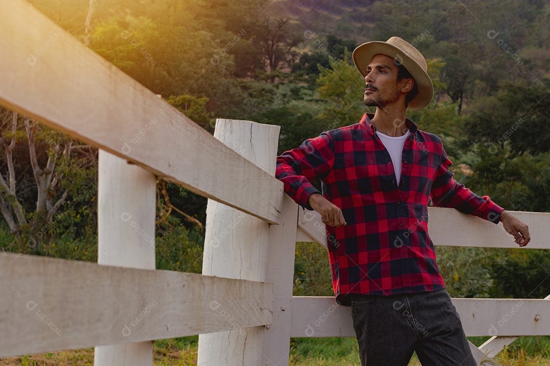 Jovem agricultor negro do sexo masculino trabalhando em frente ao portão dos agricultores.