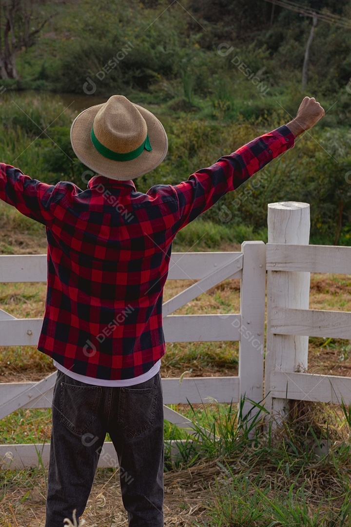 Jovem agricultor negro do sexo masculino trabalhando em frente ao portão dos agricultores.