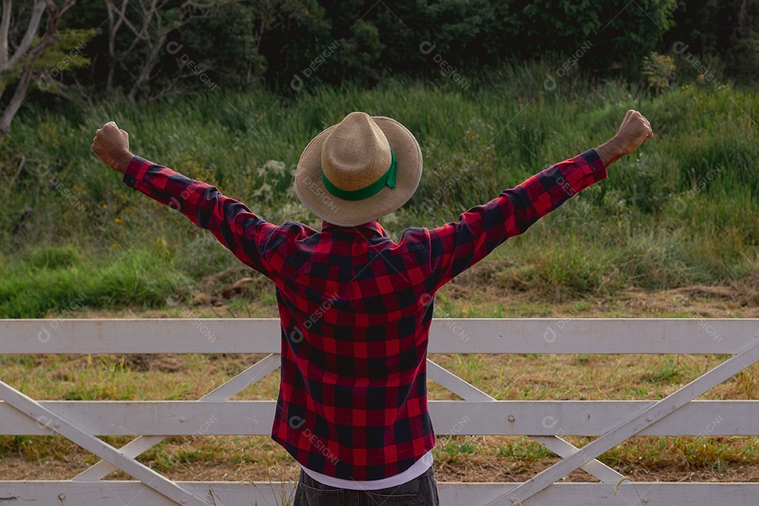 Jovem agricultor negro do sexo masculino trabalhando em frente ao portão dos agricultores.