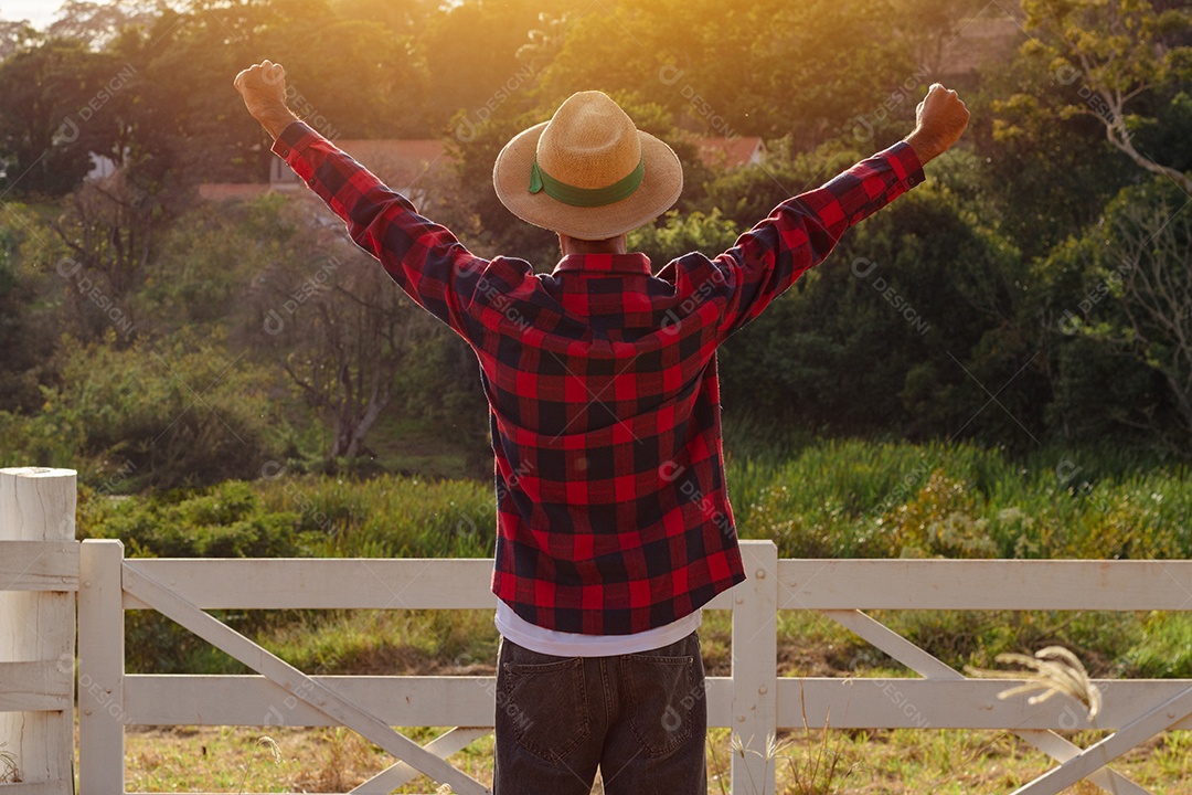 Jovem agricultor negro do sexo masculino trabalhando em frente ao portão dos agricultores.