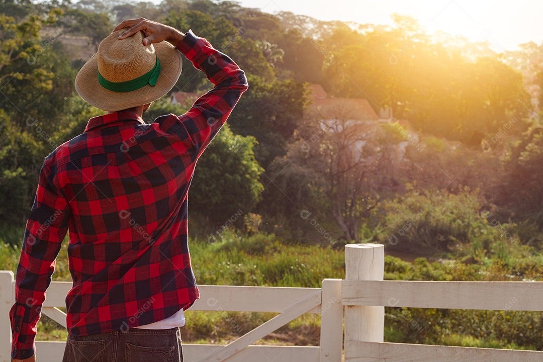 Jovem agricultor negro do sexo masculino trabalhando em frente ao portão dos agricultores.