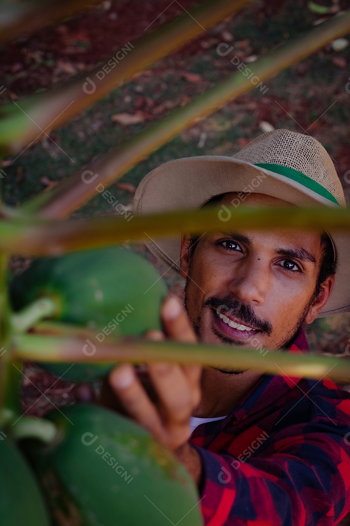 Jovem agricultor negro do sexo masculino trabalhando em frente ao portão dos agricultores.