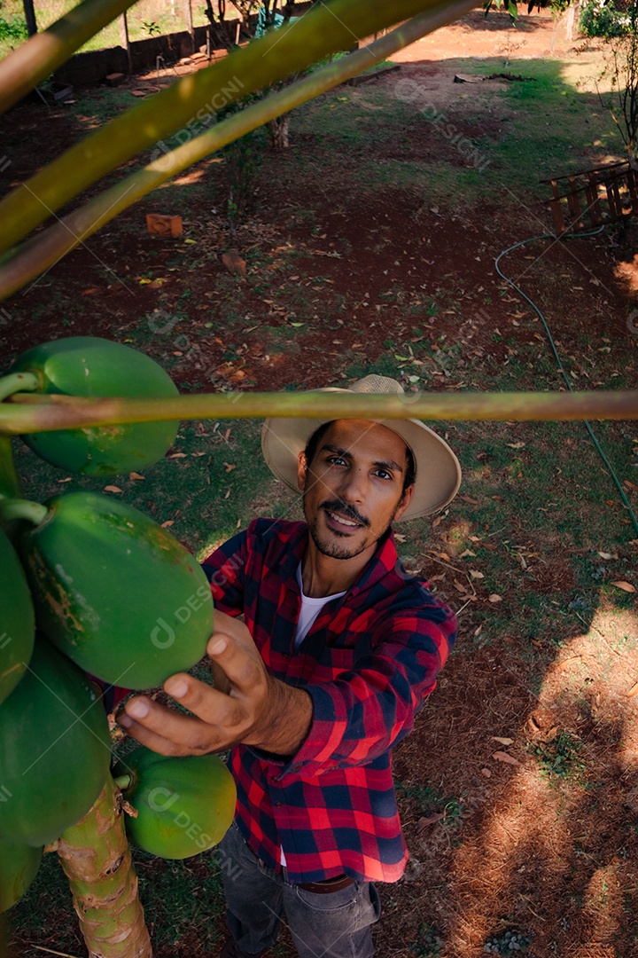 Jovem agricultor negro do sexo masculino trabalhando em frente ao portão dos agricultores.