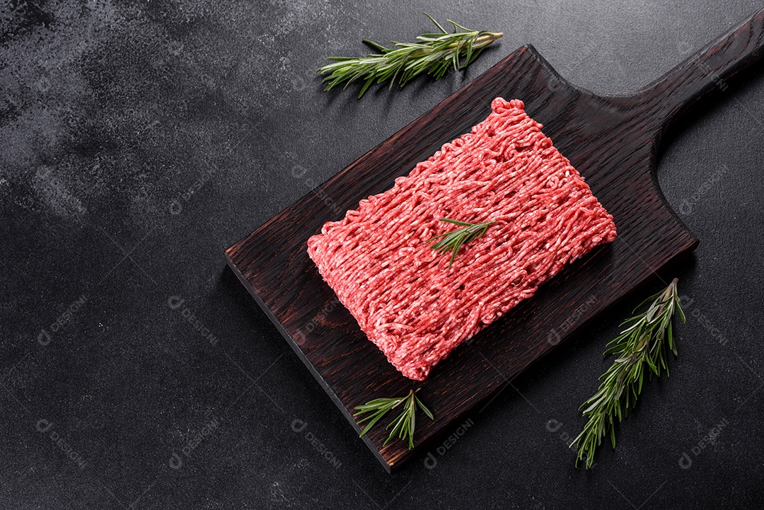 Carne crua fresca picada em um fundo escuro. Preparação para cozinhar costeletas