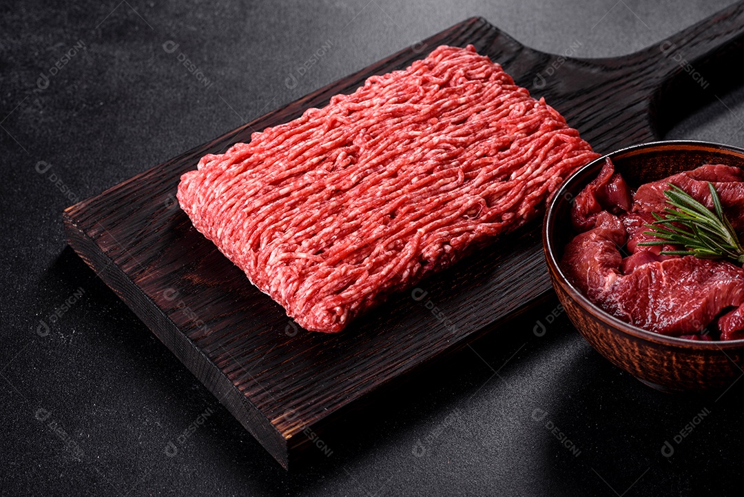 Carne crua fresca picada em um fundo escuro. Preparação para cozinhar costeletas