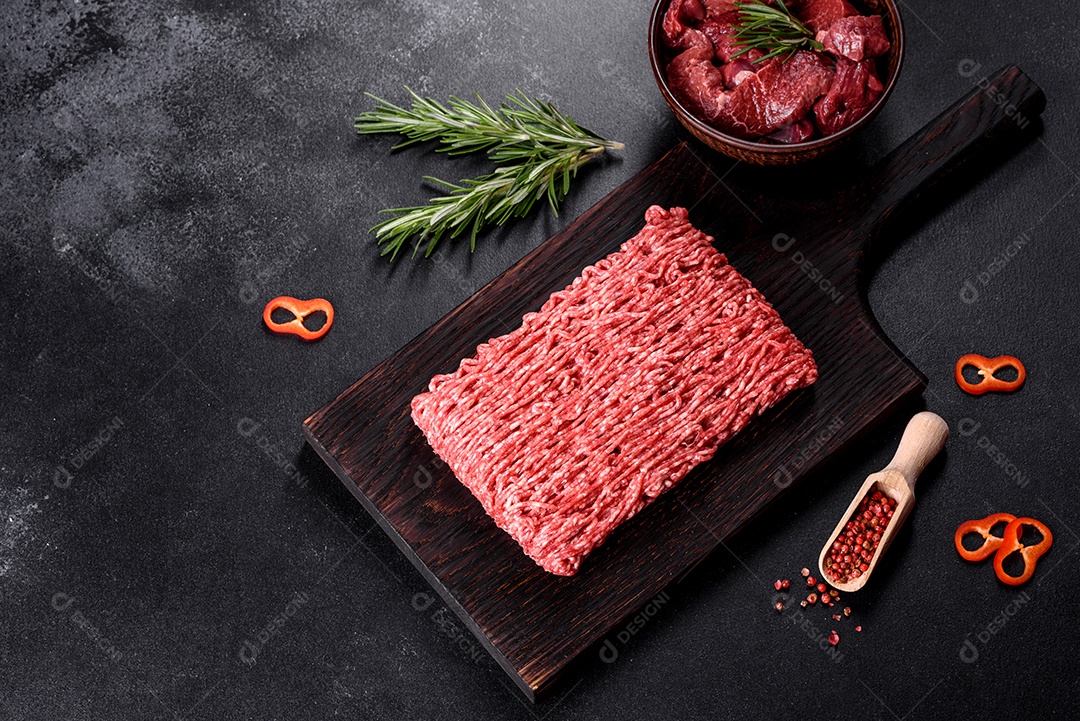 Carne crua fresca picada em um fundo escuro. Preparação para cozinhar costeletas