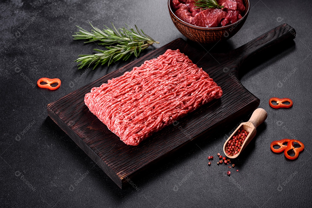 Carne crua fresca picada em um fundo escuro. Preparação para cozinhar costeletas