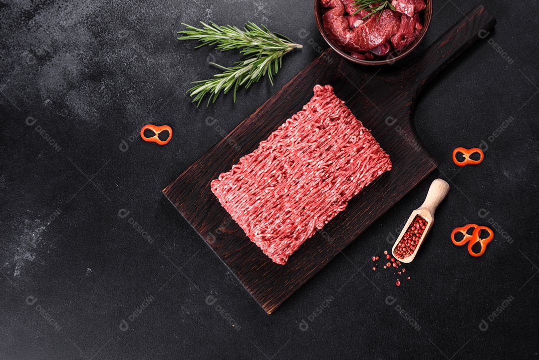 Carne crua fresca picada em um fundo escuro. Preparação para cozinhar costeletas