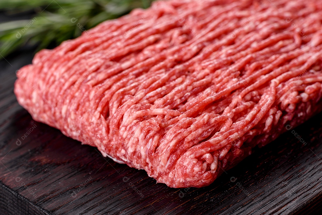 Carne crua fresca picada em um fundo escuro. Preparação para cozinhar costeletas