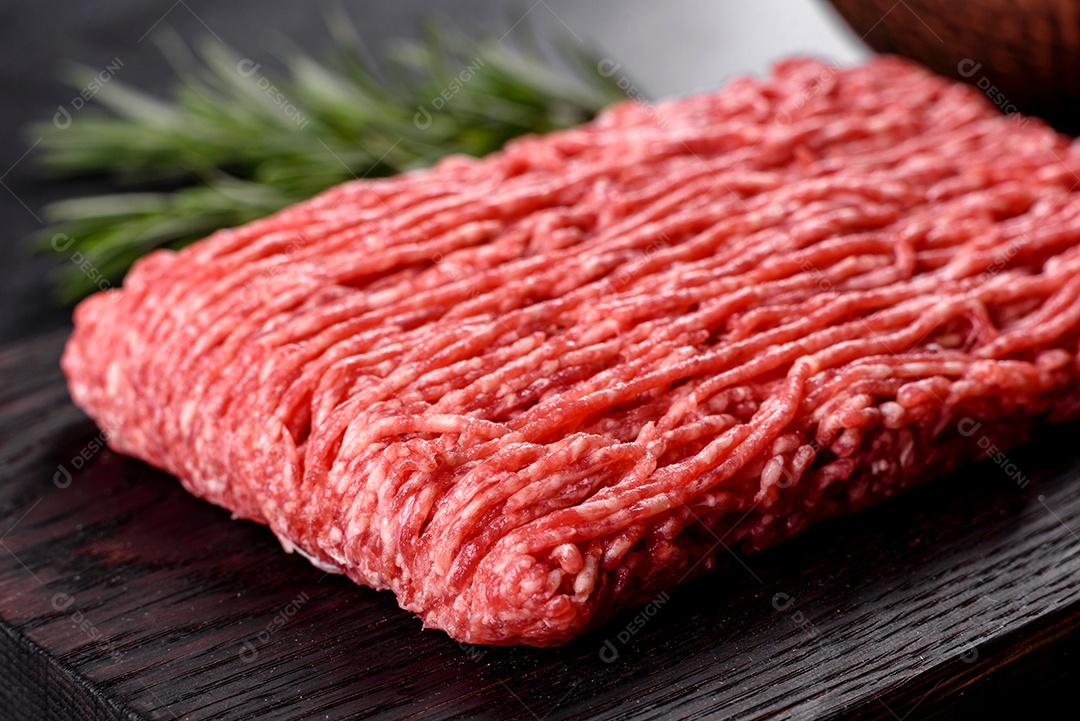 Carne crua fresca picada em um fundo escuro. Preparação para cozinhar costeletas