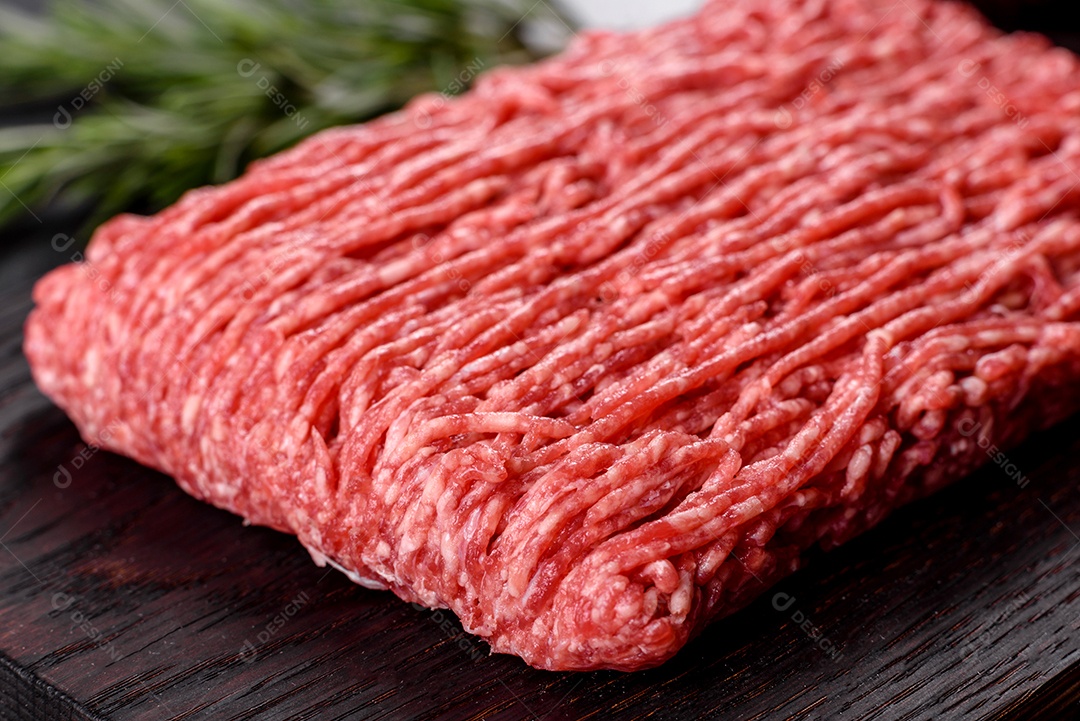 Carne crua fresca picada em um fundo escuro. Preparação para cozinhar costeletas