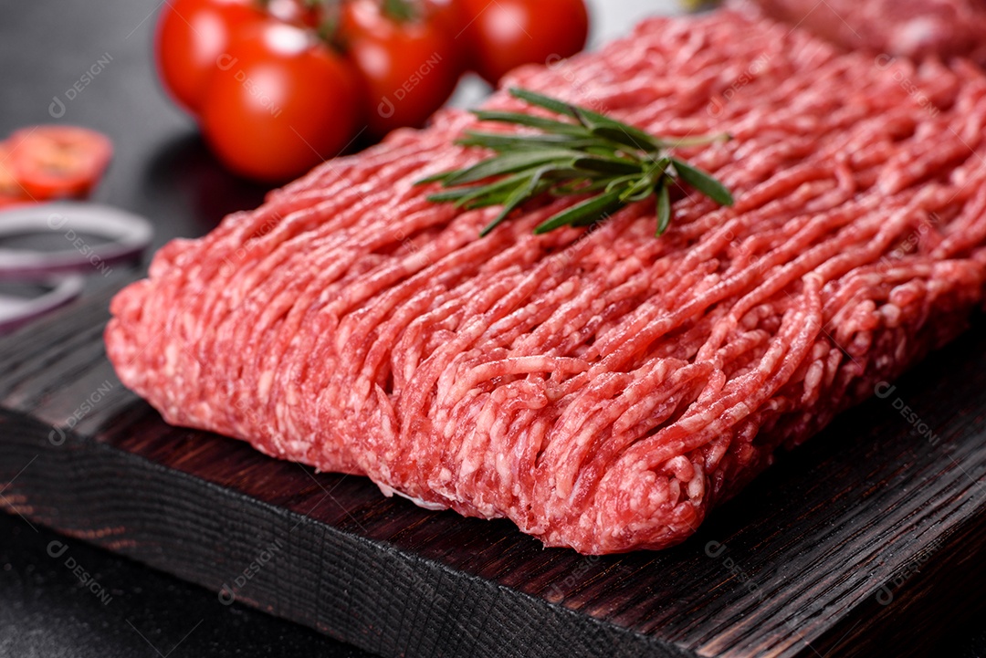 Carne crua fresca picada em um fundo escuro. Preparação para cozinhar costeletas