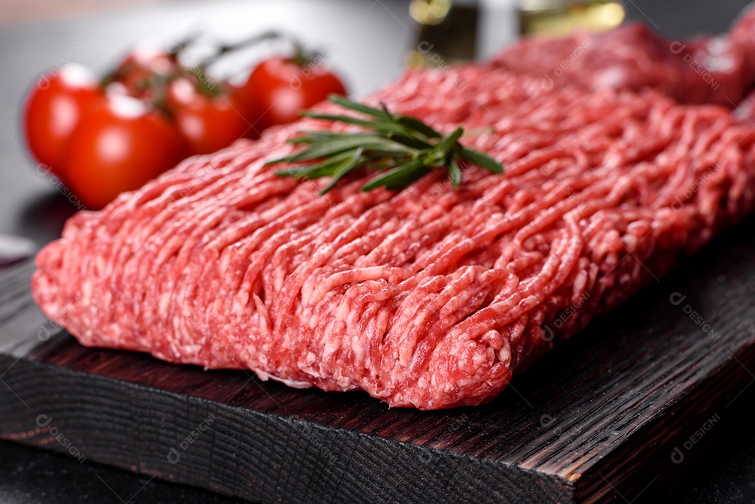 Carne crua fresca picada em um fundo escuro. Preparação para cozinhar costeletas