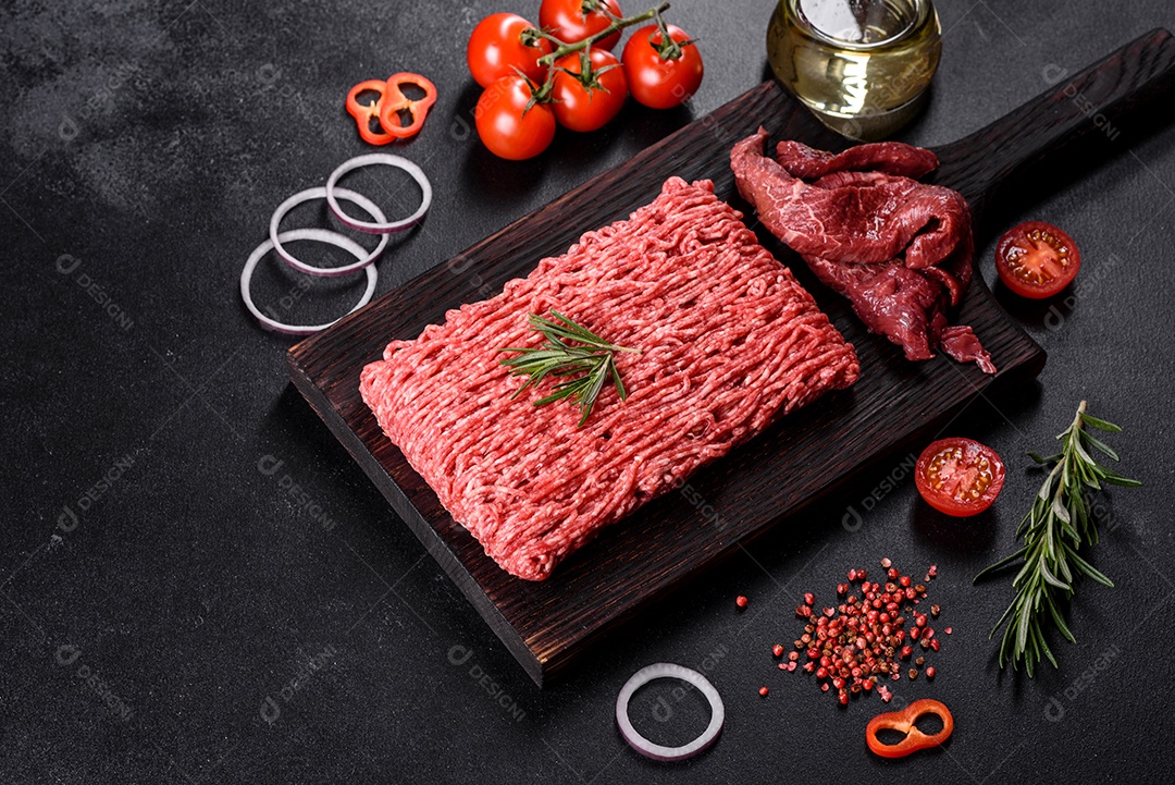 Carne crua fresca picada em um fundo escuro. Preparação para cozinhar costeletas