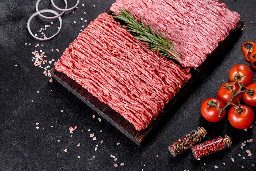 Carne crua fresca picada em um fundo escuro. Preparação para cozinhar costeletas