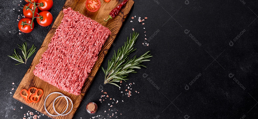 Carne crua fresca picada em um fundo escuro. Preparação para cozinhar costeletas