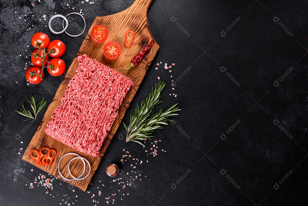 Carne crua fresca picada em um fundo escuro. Preparação para cozinhar costeletas