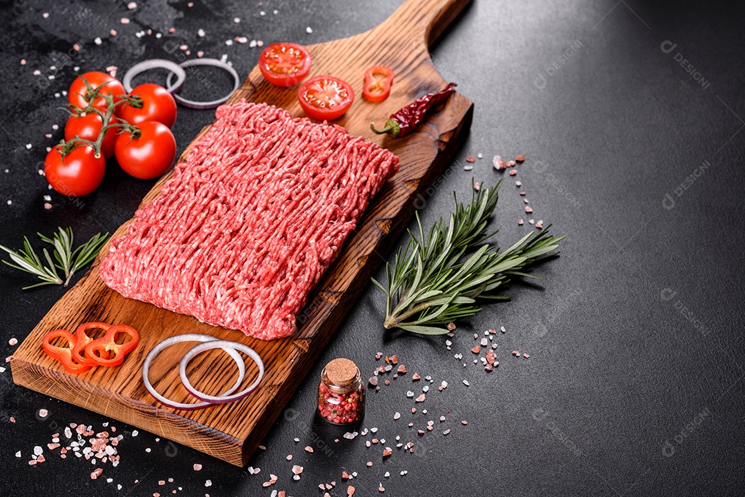 Carne crua fresca picada em um fundo escuro. Preparação para cozinhar costeletas