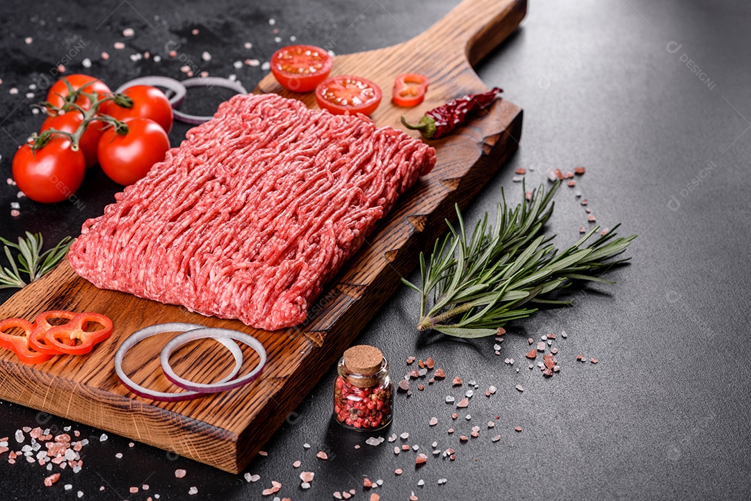 Carne crua fresca picada em um fundo escuro. Preparação para cozinhar costeletas
