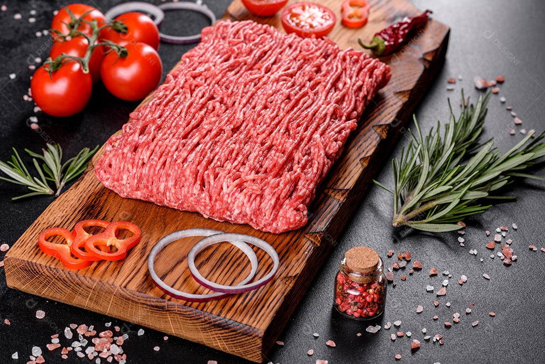 Carne crua fresca picada em um fundo escuro. Preparação para cozinhar costeletas