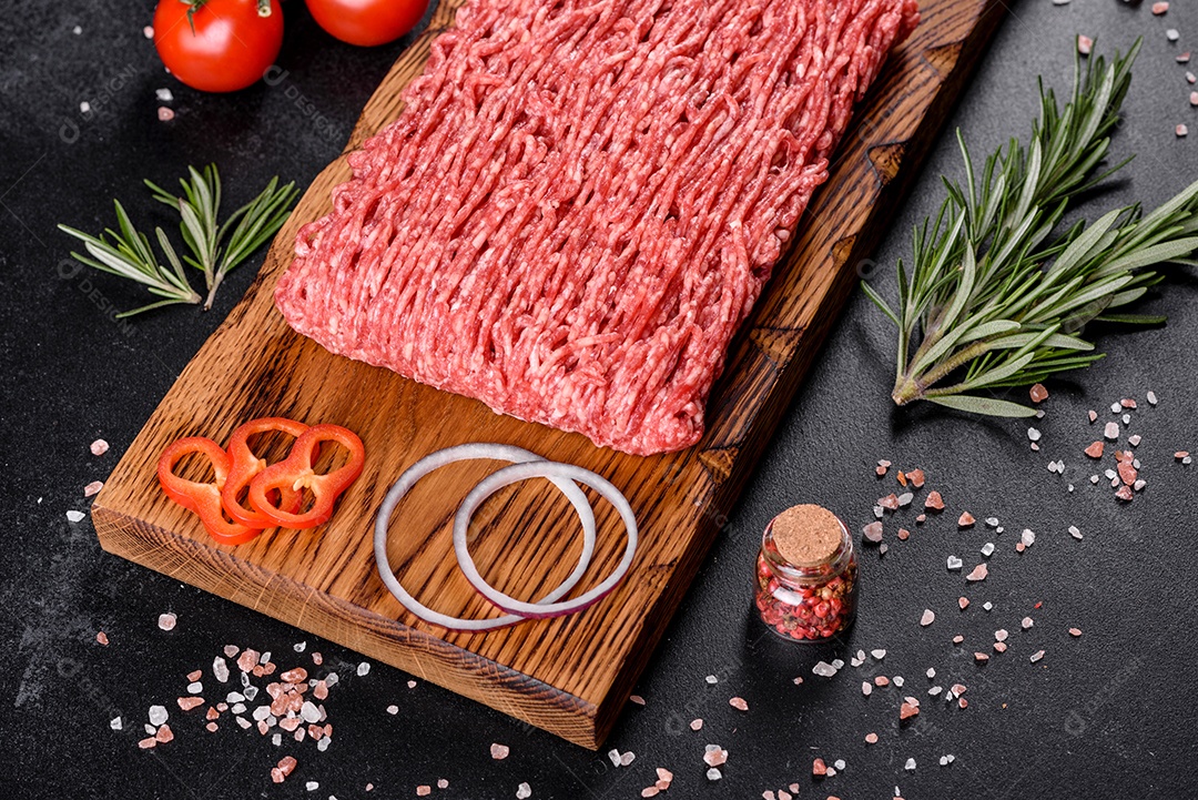 Carne crua fresca picada em um fundo escuro. Preparação para cozinhar costeletas